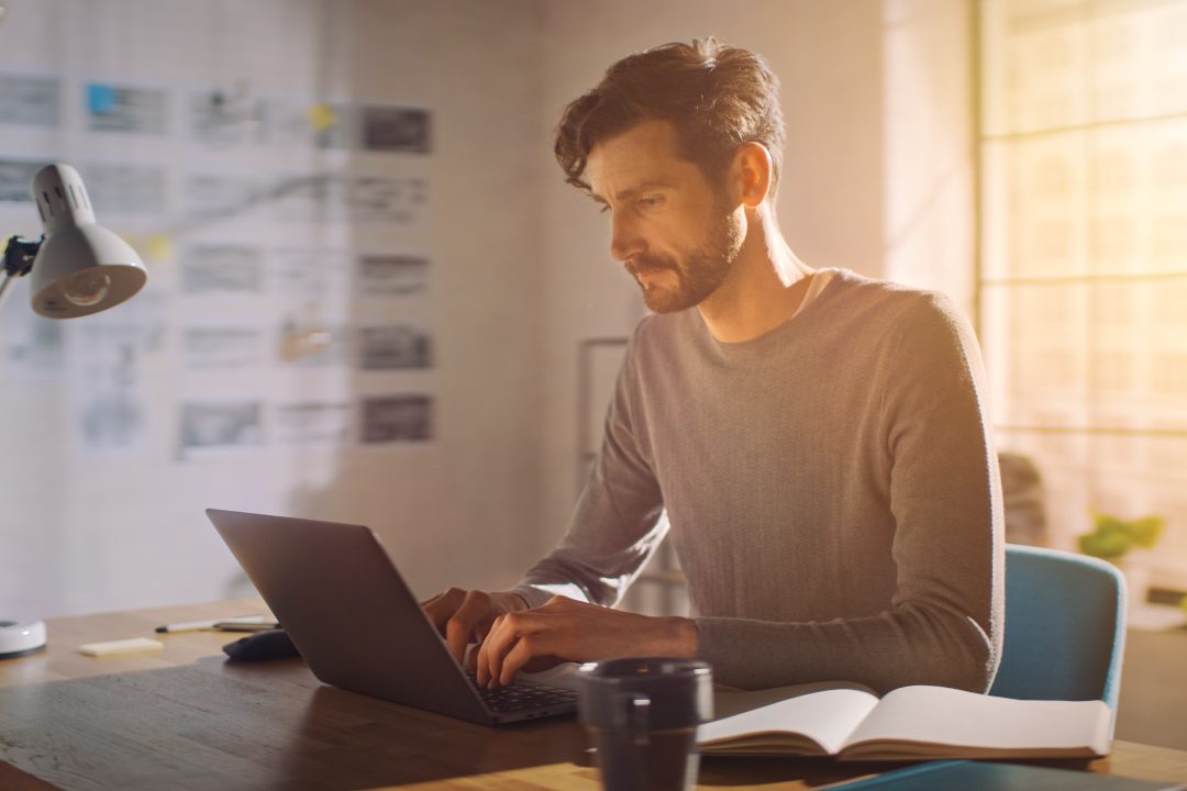 Concentrated Man Using Notebook Computer.