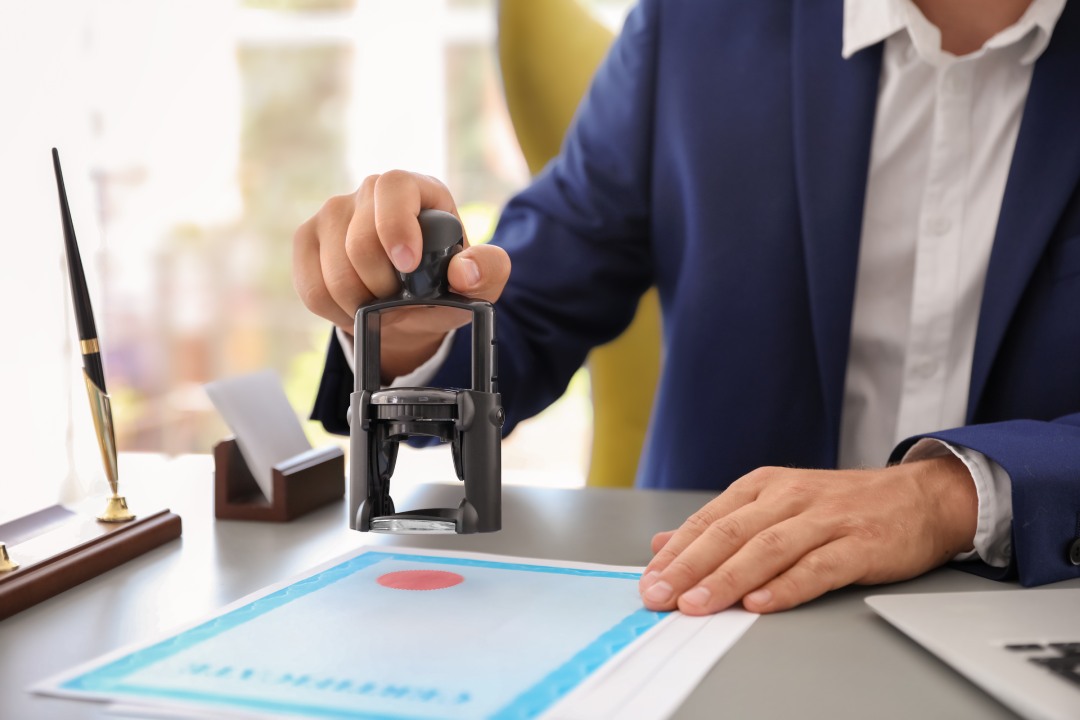 Notario sellando un documento en un despacho, primer plano