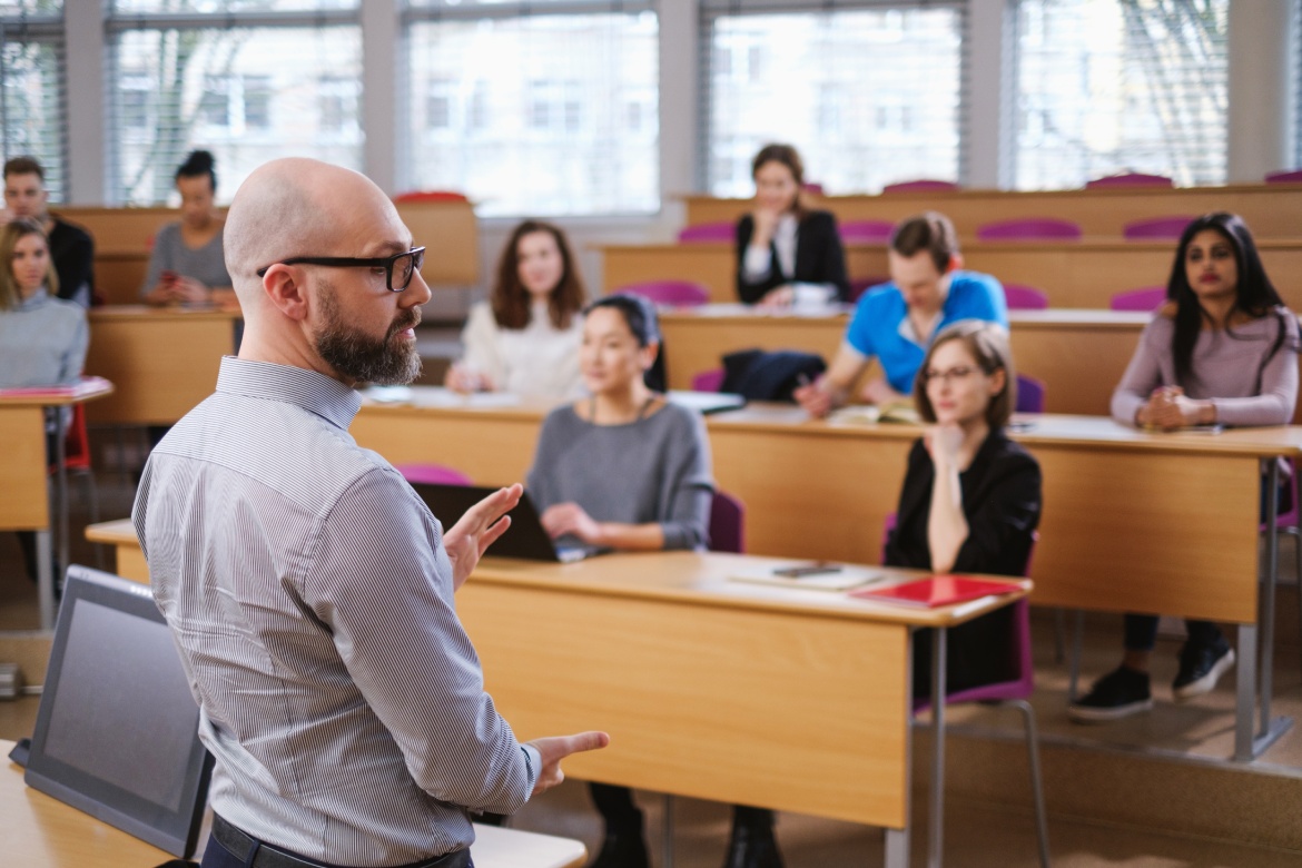 Profesor y grupo multinacional de estudiantes en un auditorio