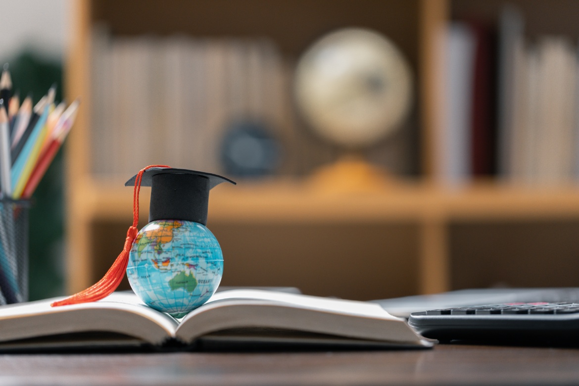Gorra de graduación con globo terráqueo. Concepto de estudio global de negocios, en el extranjero educativo, Vuelta al cole. Educación en el mundo global, Estudio en el extranjero de negocios en universidades de todo el mundo. estudio de idiomas