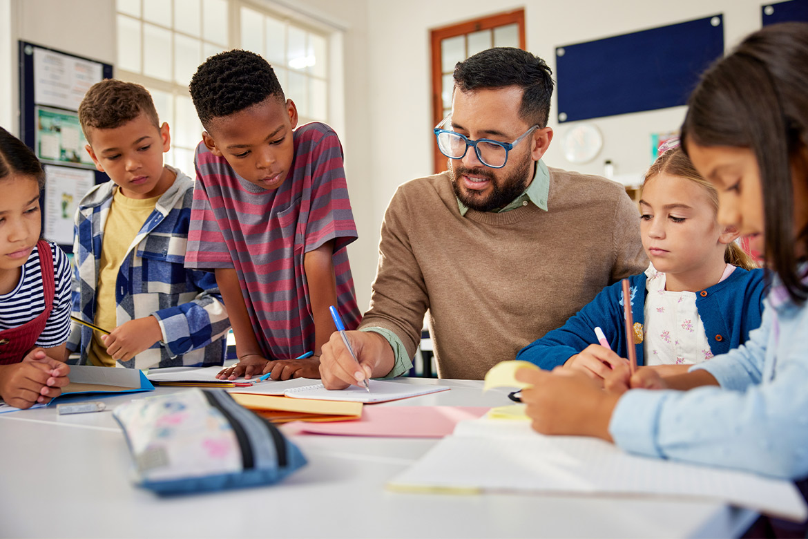 A teacher guides students through homework, promoting understanding and collaboration in their educational journey.