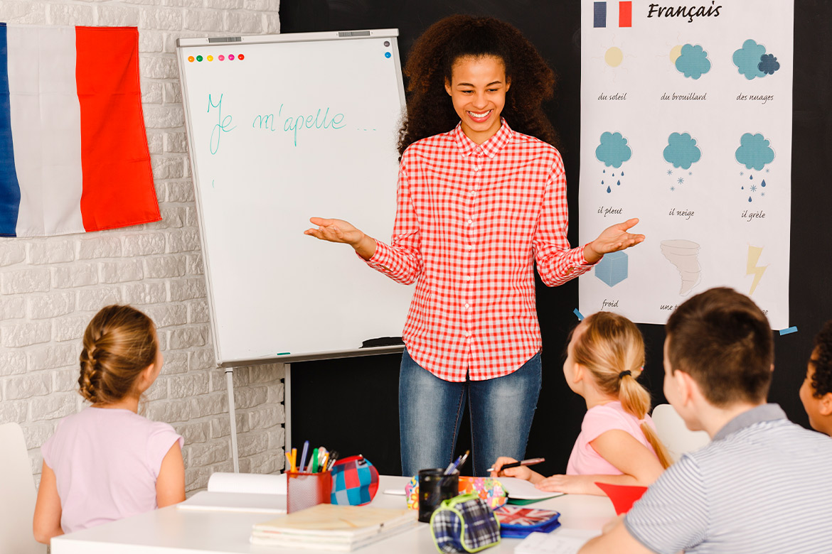 A woman instructs children in a classroom, focusing on how to become a French teacher in Texas.