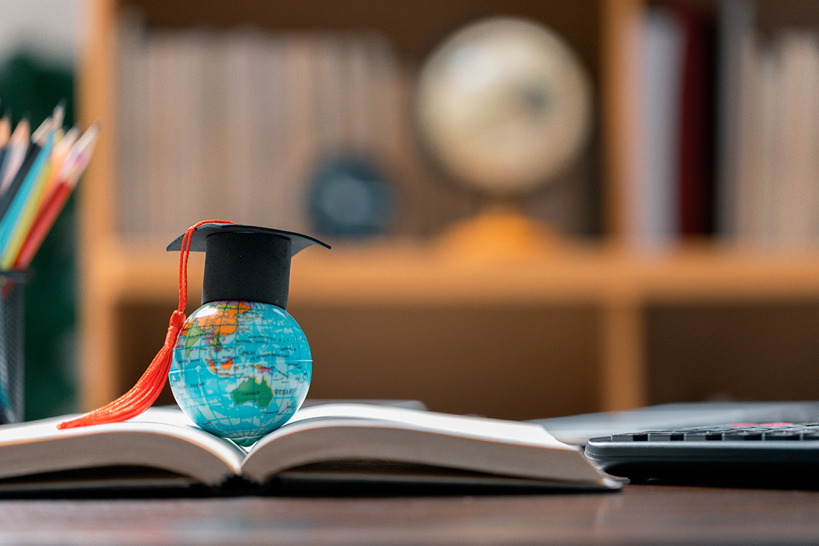 Open book with a graduation cap and school supplies, representing the journey to becoming a Chinese teacher in Texas.