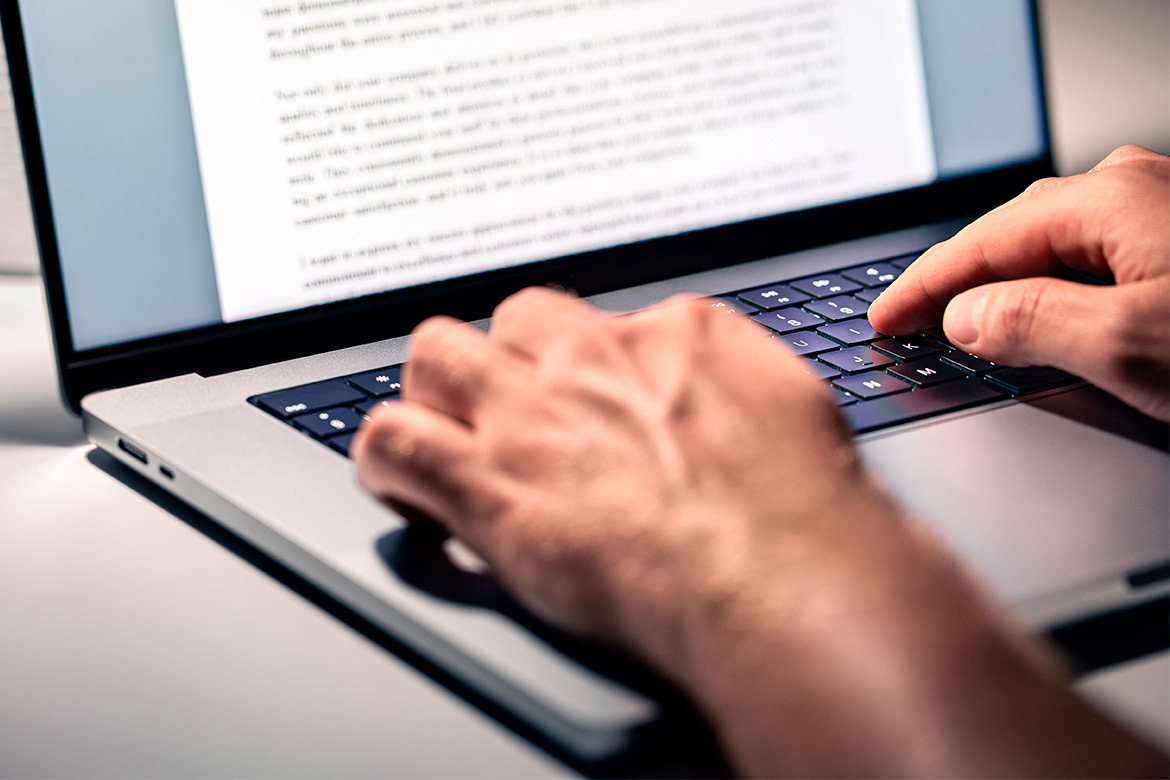 Individual typing on a laptop, exploring steps to become a Journalism teacher in Texas.