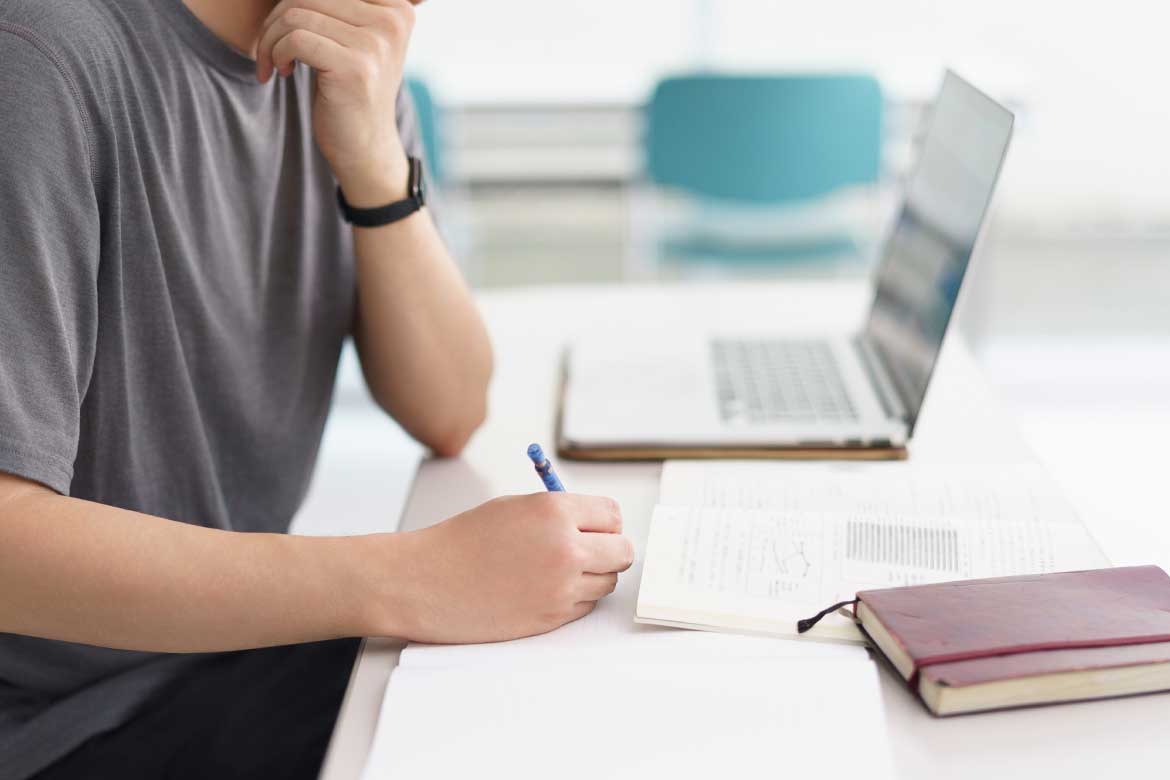 Man taking notes during online professional certification course